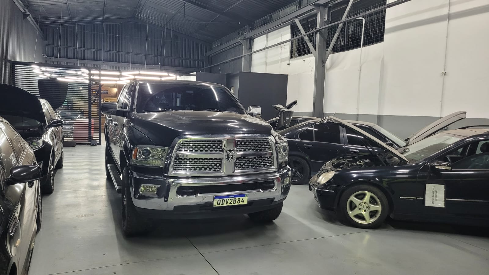 Picape RAM e Mercedes-Benz em manutenção dentro da oficina